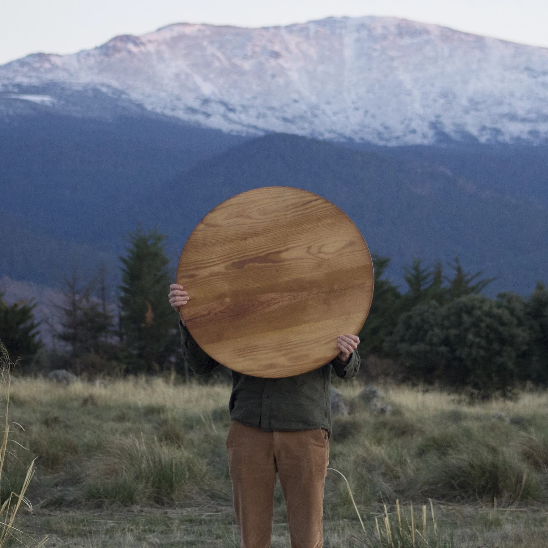 Hombre susteniendo una mesa de madera.